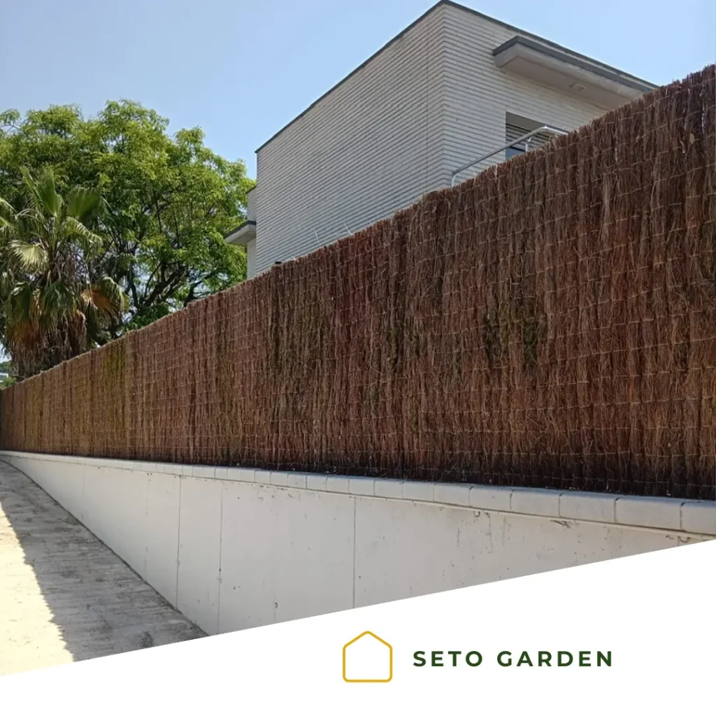 Cerramiento de terraza en Boadilla del Monte con brezo natural de alta densidad instalado sobre una valla para mejorar la privacidad.